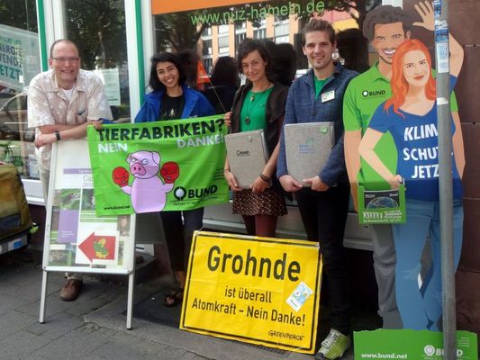 Die Kreisgruppe Hameln steht vor ihrem Büro mit Fahnen vom BUND und einem Schild von Grohnde